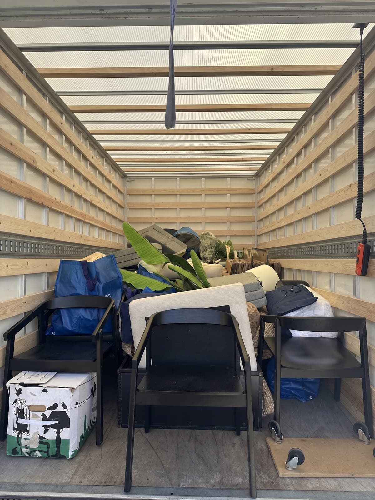 De bakwagen vol meubels en planten, klaar om te vertrekken