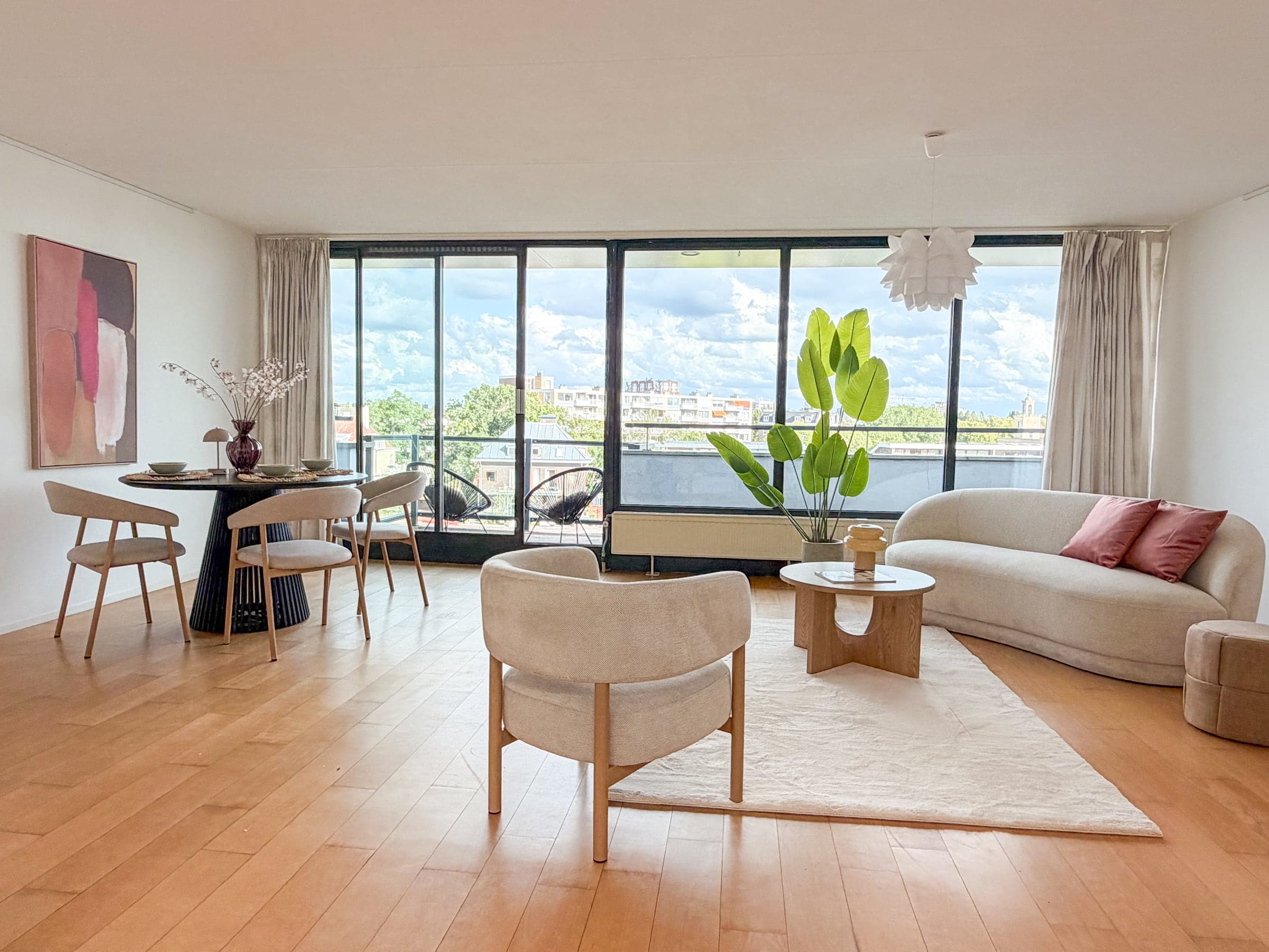 Woonkamer met een raampartij over de volle breedte in een appartement in Leiden, gestyled door Stijlvol Verkocht